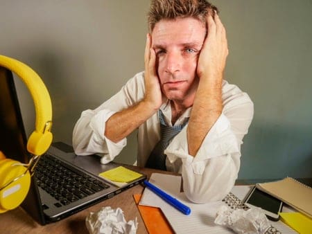 a man sitting at a desk with a laptop and headphones