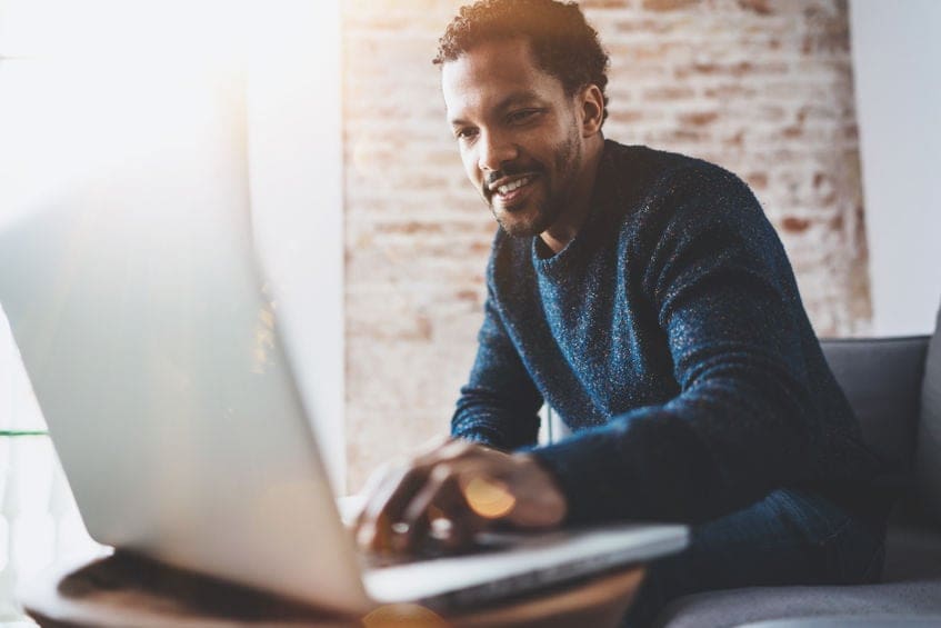 a man sitting in front of a laptop computer