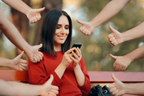 a woman sitting on a bench with her hands in the air