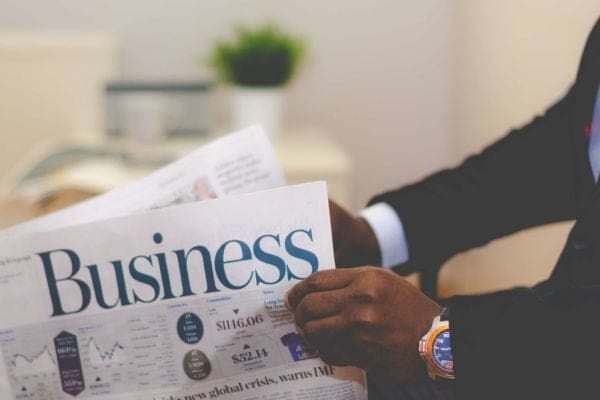 a man in a suit reading a newspaper