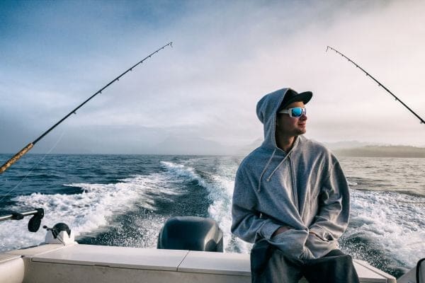 a man sitting on a boat while fishing