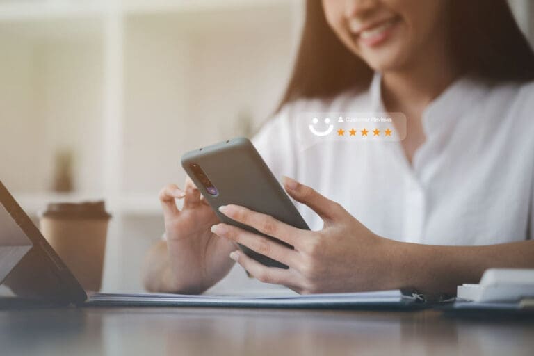 a woman sitting at a table using a tablet